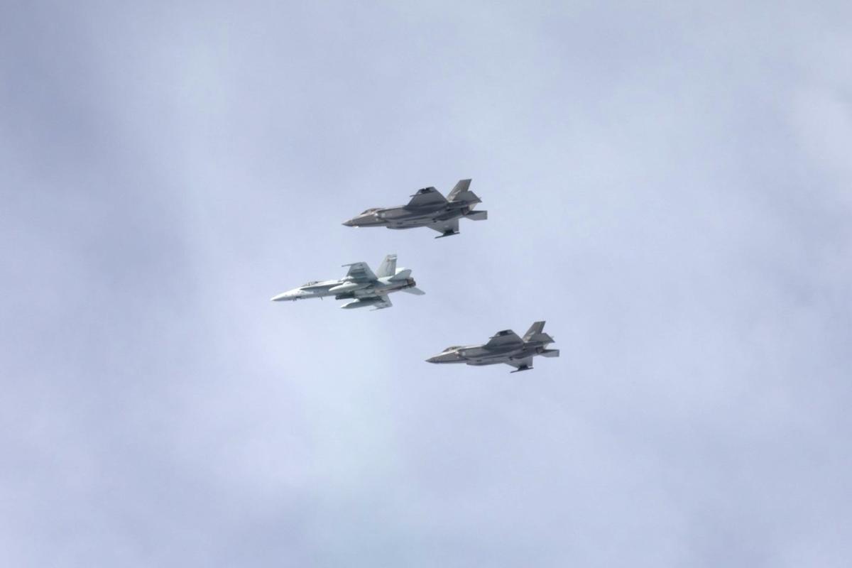 Kuvituskuva, jossa Ilmavoimien Hornet-hävittäjä lentää harmaalla taivaalla molemmilla siivillään norjalainen F-35-hävittäjä.