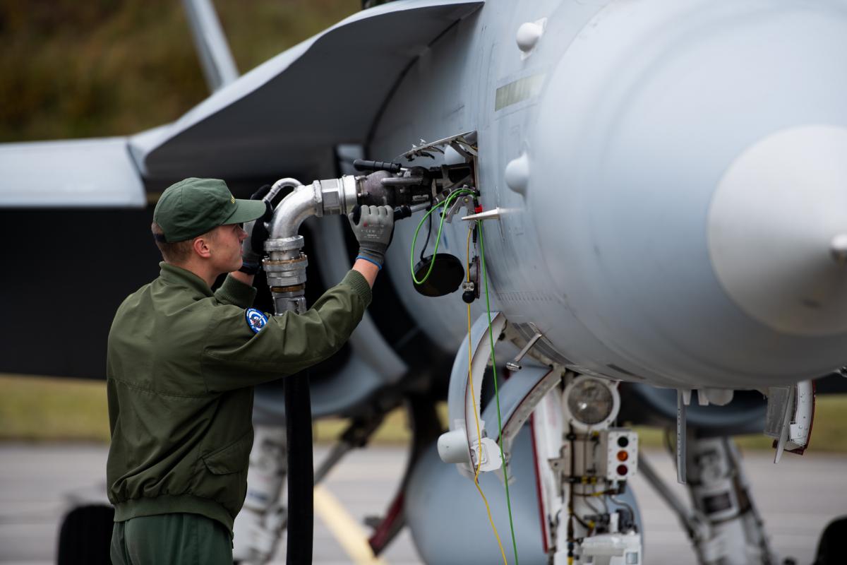 Apumekaanikko tankkaa F/A-18 Hornet -hävittäjää.