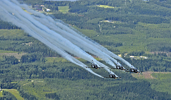 Midnight Hawks taitolentoryhmän neljä konetta ilmassa kesäisessä maisemassa.