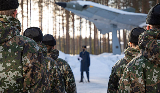 Ilmasotakoulun varusmiehiä ulkona riveissä kuuntelemassa Ilmasotakoulun johtajan puhetta.