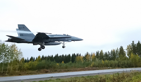 Hornet-monitoimihävittäjä laskeutumassa maantielle noin kymmenen metrin korkeudessa