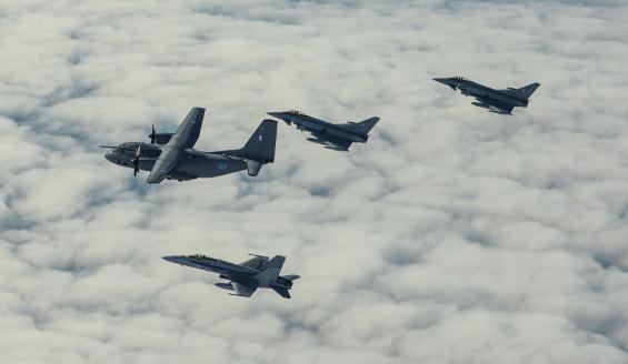 Liettualainen C-27 J Spartan, suomalainen F/A-18 Hornet ja kaksi saksalaista Eurofighter Typhoon -konetta lentävät pilvien yläpuolella