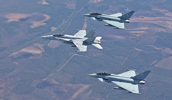 Finnish Air Force F/A-18 and two German Air Force Eurofighters flying together.