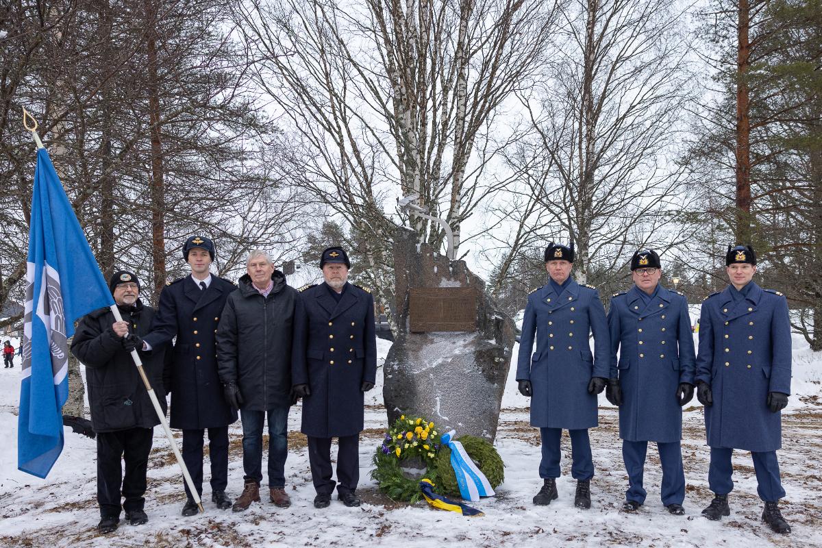 Ruotsin ja Suomen ilmavoimien edustajia seisoo F19-muistomerkin vierellä. Muistomerkin eteen on laskettu kaksi havuseppelettä.