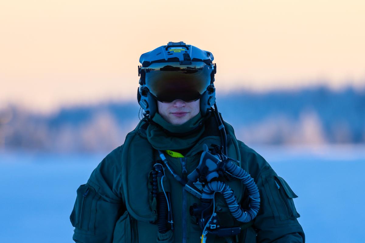 Hävittäjälentäjä suoraan edestä kuvattuna, kypärän visiiri alhaalla.