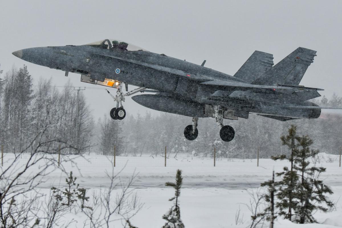 Hornet-hävittäjä nousee ilmaan maantieltä talvella.