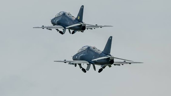 Kaksi harmaata Hawk-suihkuharjoituskonetta nousussa sulkemassa laskutelineitä