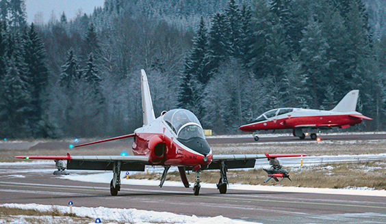 Kaksi punavalkoista Hawk-suihkuharjoituskonetta rullaamassa talvisella lentokentällä