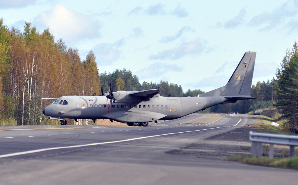 Kuvassa ilmavoimien CASA C-295M -kuljetuskone on rullamassa kiitotiellä. Sää on kuvassa aurinkoinen ja koneen taustalla näkyy puita.