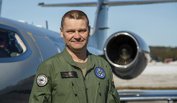 Kenraalimajuri Juha-Pekka Keränen seisoo lentohaalareissa Ilmavoimien Learjet-koneen edessä aurinkoisen päivänä.