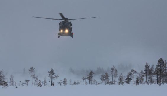 Lumi pöllyää, kun ohjaajat viedään helikopterilla sovittuun paikkaan.