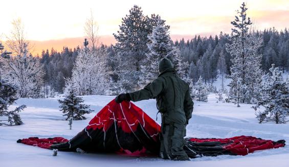 Ohjaaja levittää laskuvarjoa maastoon