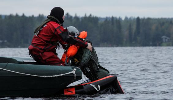 Pintapelstaja nostaa ohjaajan pelastuslautalta veneeseen.