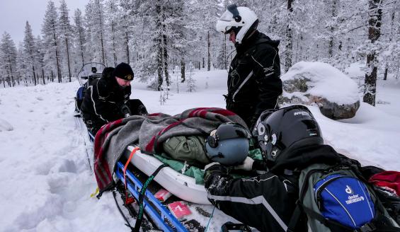 Pelastuspartio siirtää potilaan ahkion kyytiin