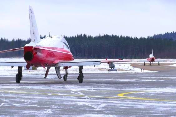 Kaksi punavalkoista Hawk Mk 66 -suihkuharjoituskonetta rullaa talvisella kiitotiellä.