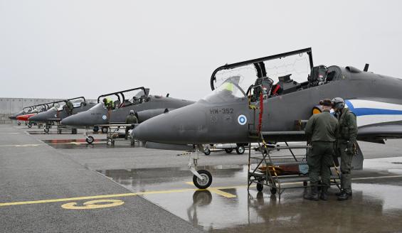 Hawk-suihkuharjoituskoneita seisoo rivissä, ja lentäjät valmistautuvat mekaanikkojen tuella seuraavaan lentoon. 