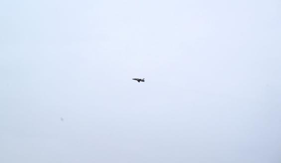 Hawk-suihkuharjoituskone lentämässä pilvistä taivasta vasten. 
