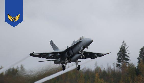 Hornet monitoimihävittäjä nousee ilmaan syksyisenä päivänä. Siipien kärjistä muodostuu tiivistevanat.