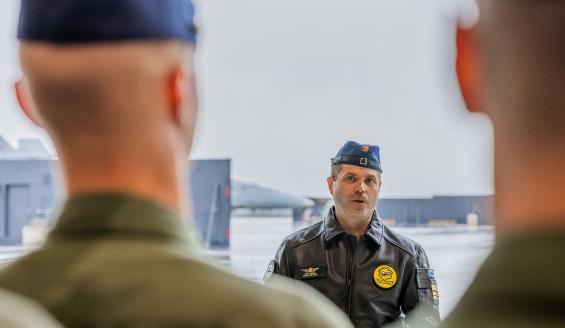 Everstiluutnantti Lasse Louhela puhuu henkilöstölleen, jonka ensimmäisen rivin takaa kuva on otettu.