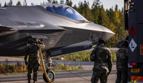 Maassa otettu lähikuva yhdysvaltalaisen F-35-hävittäjän keulasta. Yhdysvaltalaissotilaat tankkaavat hävittäjää Hosion varalaskupaikalla. Taustalla näkyy syksyistä suomalaista metsää. 