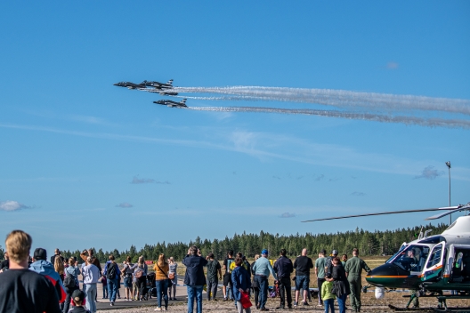 Ilmavoimien Midnight Hawks taitolento-osasto lentää muodostelmassa yleisön seuratessa esitystä Sotilasilmailusta ammatti -tapahtumassa.