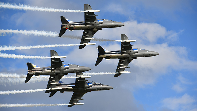 Ilmavoimien taitolento-osasto Minght Hawks lentää tiukassa vinoneliömuodostelmassa neljällä suihkuharjoitushävittäjällä sinisellä taivaalla.